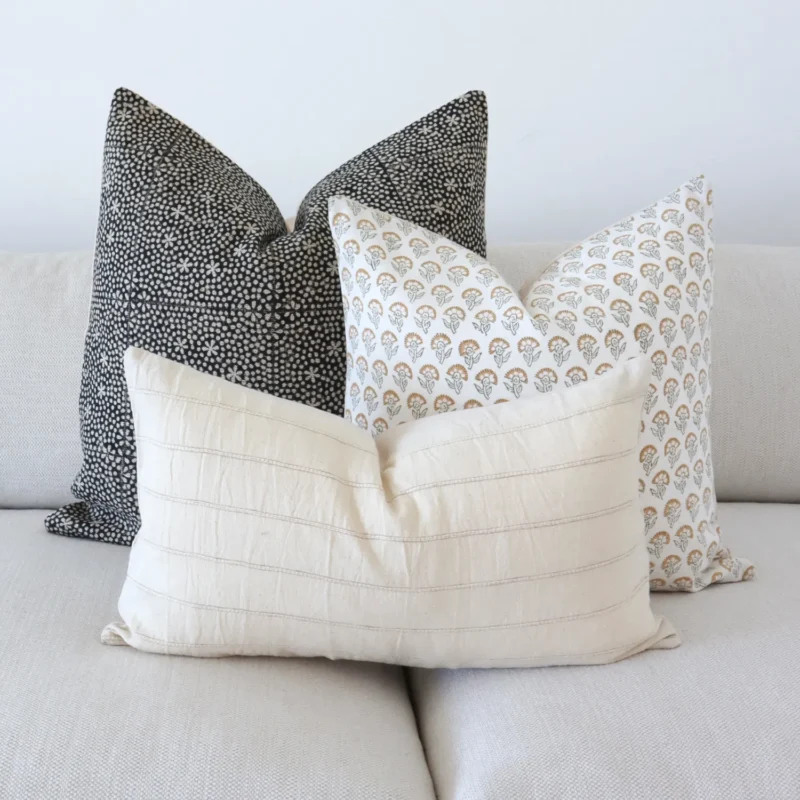 The Essa designer couch cushions are beautifully arranged on a grey sofa.