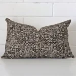 Cushion leans elegantly against a brick wall. It has been crafted from a high quality designer material and has a rectangle shape.