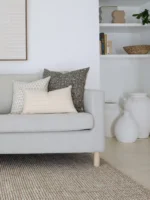 3 of 5 Essa designer cushions are neatly arranged on a gray sofa in perfect coordination.