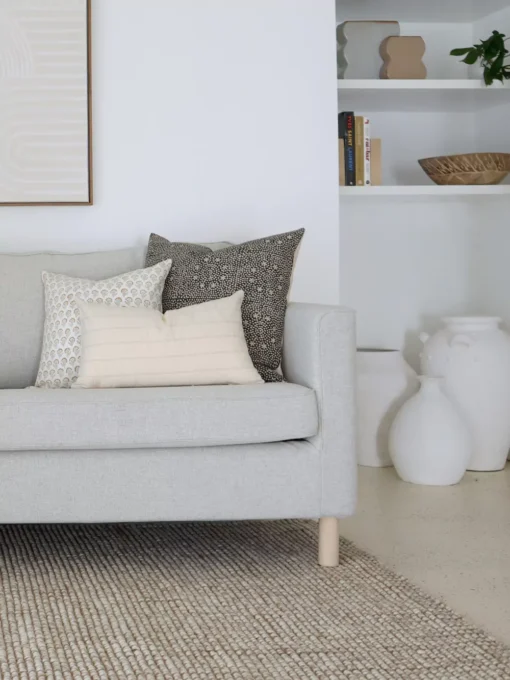 3 of 5 Essa designer cushions are neatly arranged on a gray sofa in perfect coordination.