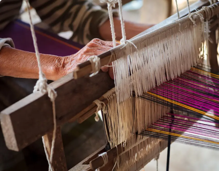 Some fabric is being created using a traditional hand loom.