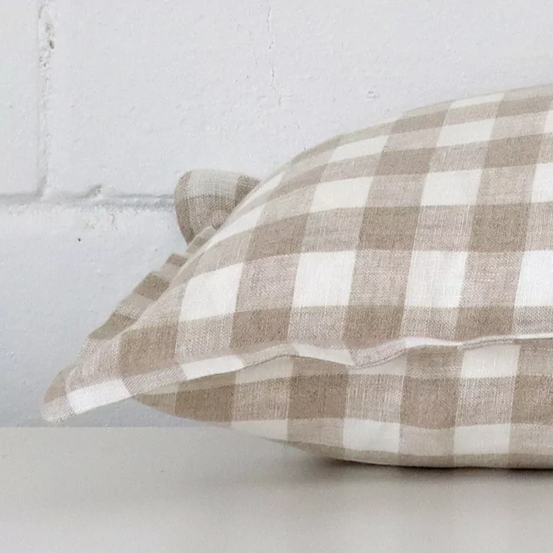 Horizontal edge of gingham large cushion cover is shown. The designer fabric can be seen from this side view.