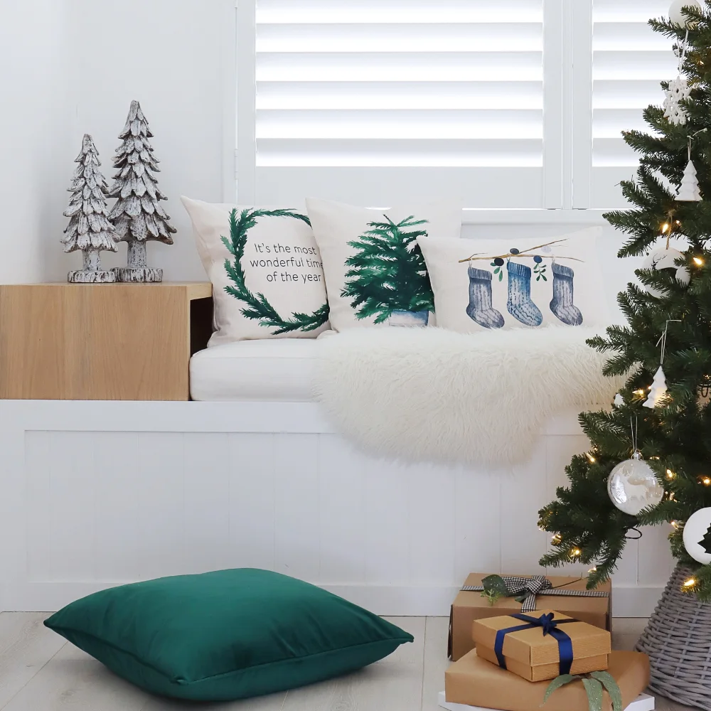 A festive scene is shown with three Christmas cushions.