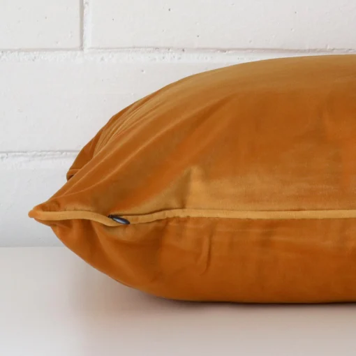 The seams of this velvet large cushion cover in gold mustard are shown.