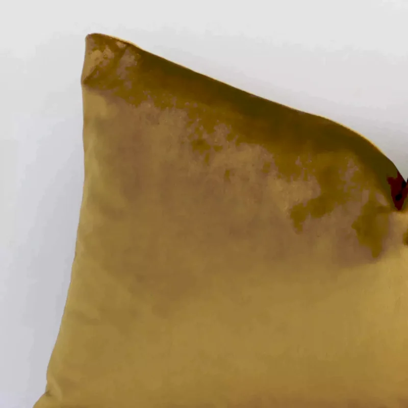 Close up image of velvet rectangular cushion. The image allows you to see the gold mustard hue and solid colour style more thoroughly.