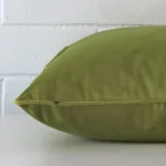 Horizontal edge of large cushion cover is shown. The velvet fabric and green tone can be seen from this side view.
