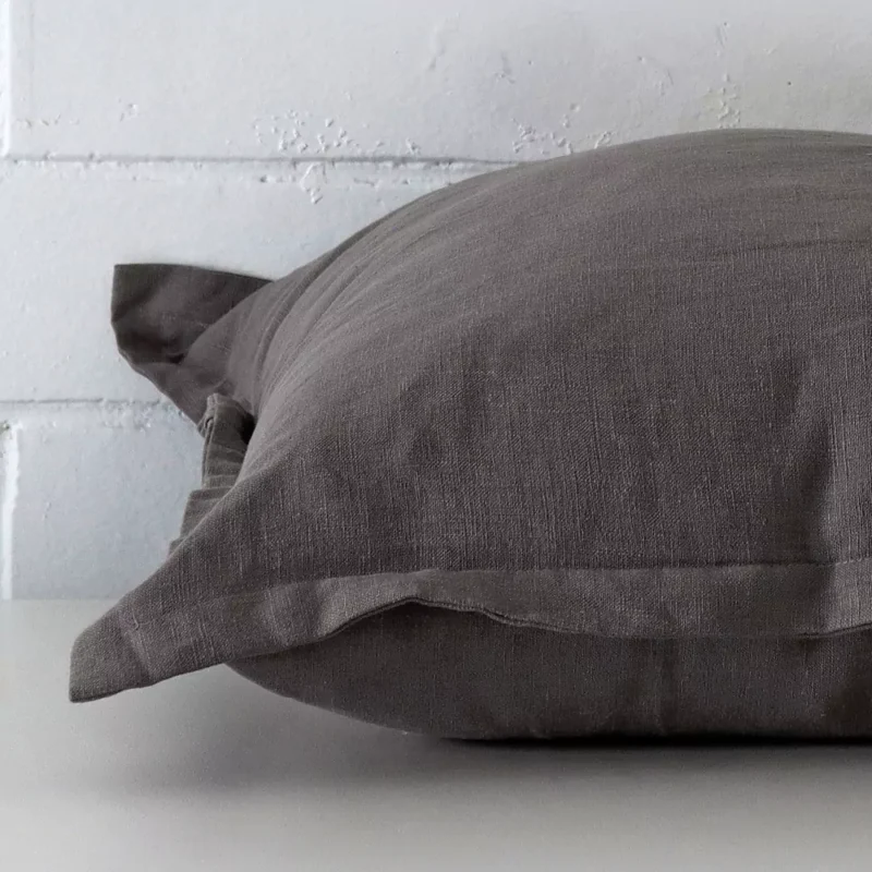 Horizontal edge view of front and back panels of a linen cushion in a large size and with grey colouring.