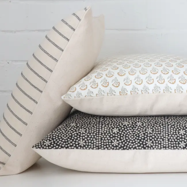 Three handcrafted designer cushions are styled in front of a white background.