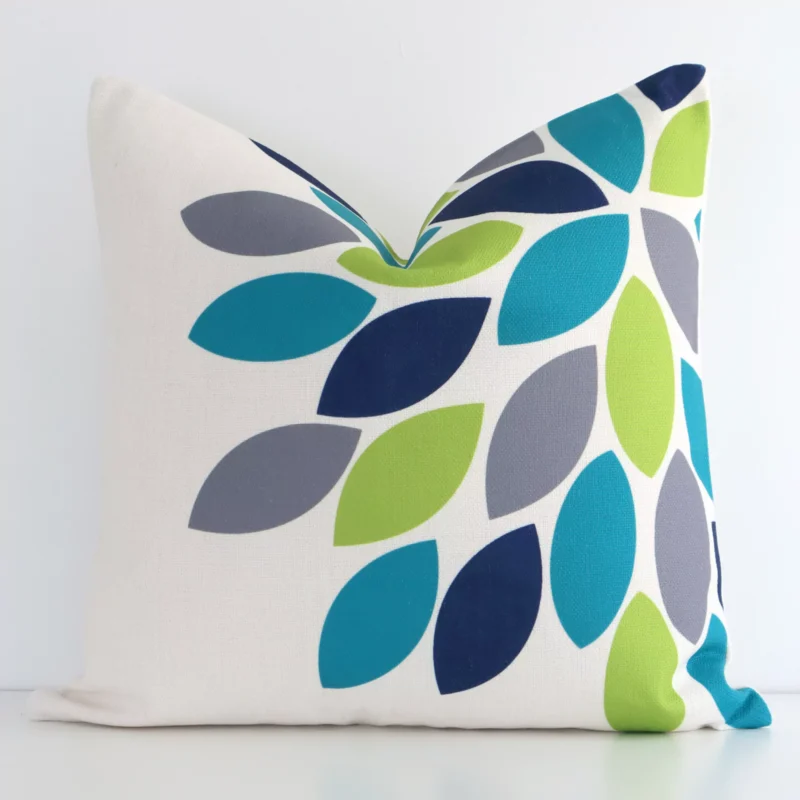 havana-shoots-cushion-cover---45cm-x-45cm---sc180-45 White wall with a patterned colourful cushion laying against it. It has a distinctive linen fabric and has a square shape.