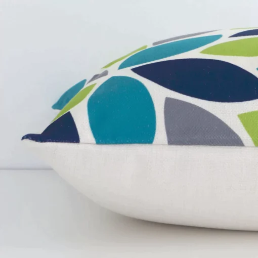 Linen colourful cushion laying on its side. The patterned design and its square shape are visible.