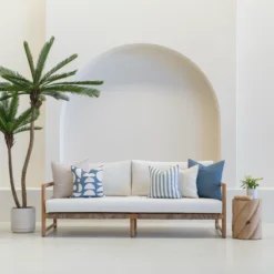 A set of 5 horizon cove outdoor cushions sitting on a wooden sofa in an airy white living room.