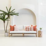 Outdoor seating with a white sofa displaying a set of 5 horizon rust outdoor cushions.