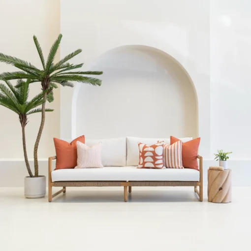 Outdoor seating with a white sofa displaying a set of 5 horizon rust outdoor cushions.