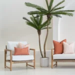 Outdoor seating displaying 4 horizon rust outdoor cushions on a white sofa.