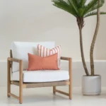A wooden armchair displaying 2 horizon rust outdoor cushions.