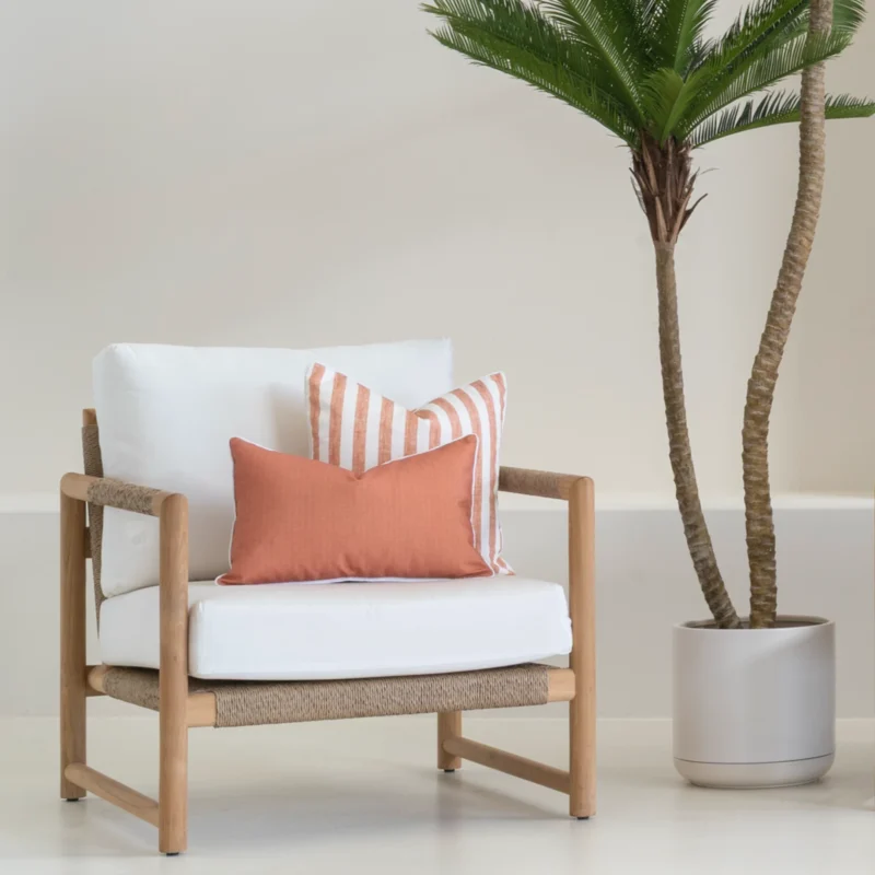 A wooden armchair displaying 2 horizon rust outdoor cushions.