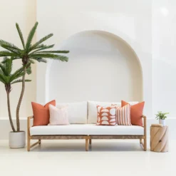 Living room scene with 5 horizon rust outdoor cushions arranged on a sofa.