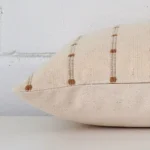 A designer cushion cover shown laying on its side. The striped design and its rectangle size are shown side on.