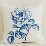 Blue statement floral cushion cover on cream cotton-linen fabric.