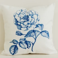 Blue statement floral cushion cover on cream cotton-linen fabric.
