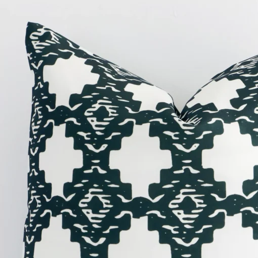 Very close photo of a squared shape geometric cushion. The shot shows the outdoor material and its dark green colour print with more clarity.