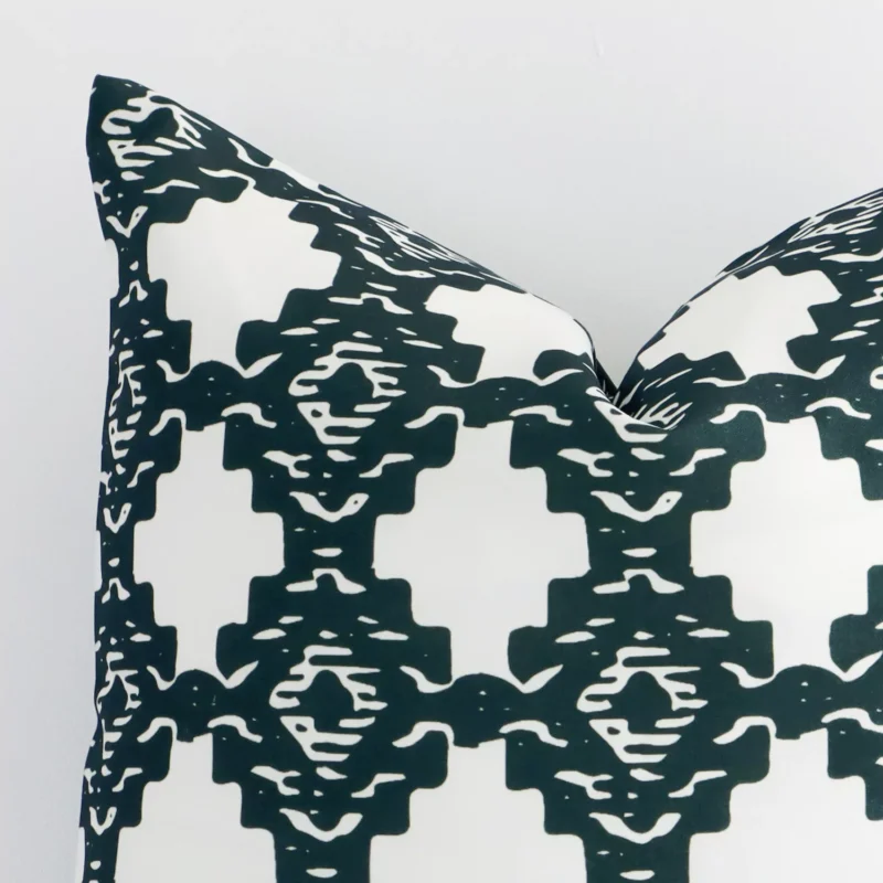 Very close photo of a squared shape geometric cushion. The shot shows the outdoor material and its dark green colour print with more clarity.