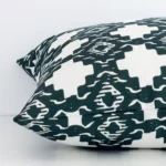 Side edge of geometric square cushion. The outdoor material and dark green colour can be seen from this lateral viewpoint.