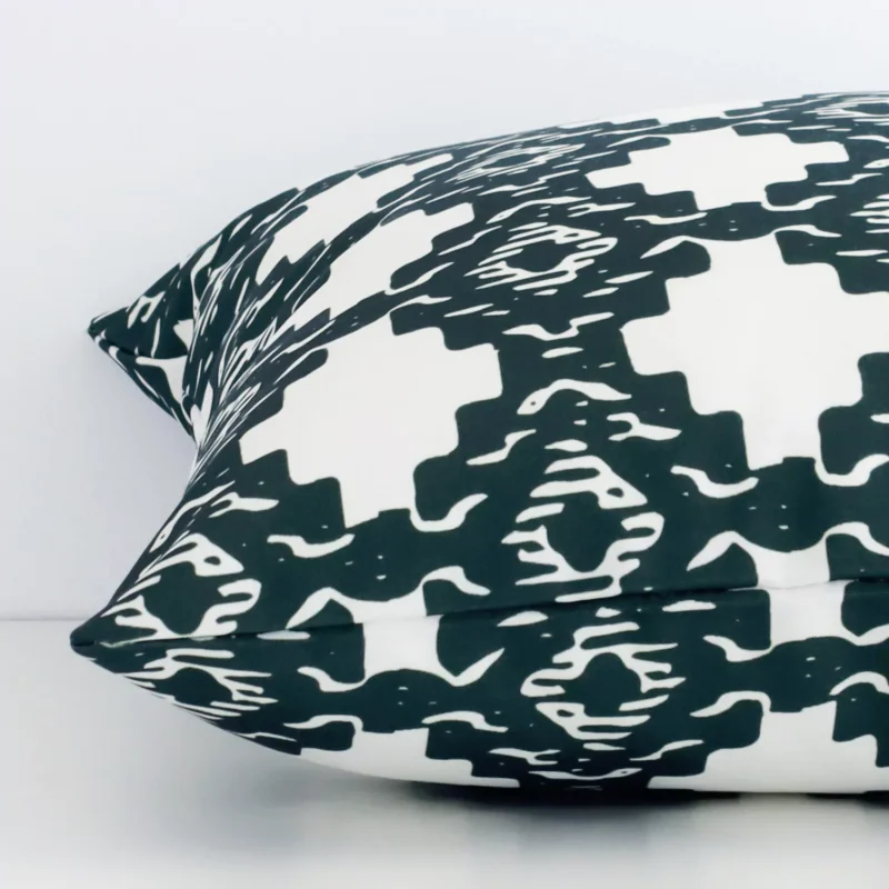 Side edge of geometric square cushion. The outdoor material and dark green colour can be seen from this lateral viewpoint.