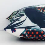 The edge of this outdoor square cushion is shown. The shot shows the tropical design and the front and rear panels.