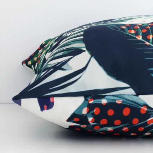 The edge of this outdoor square cushion is shown. The shot shows the tropical design and the front and rear panels.