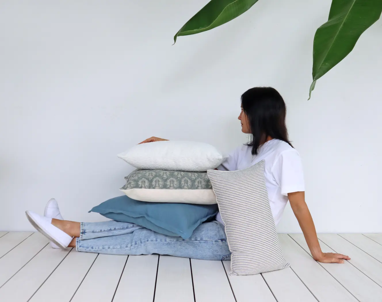 A lady is seated and has cushion covers arranged all over her lap.