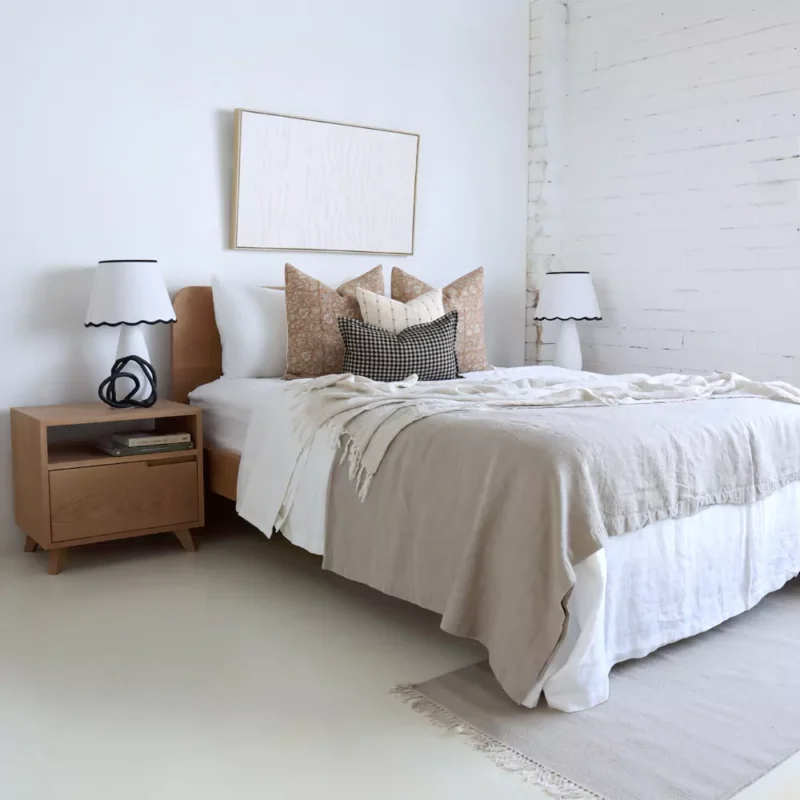 In a bright bedroom where you will find the Laurel bed cushion set, displaying four designer cushions neatly arranged on a bed.