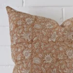 Enlarged shot of the corner of this large floral cushion cover is shown against a brick wall. The image shows the quality and craftsmanship of the material.