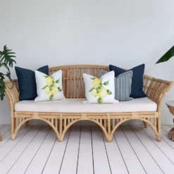An inviting outdoor lounge area featuring a comfortable seat adorned with 5 beige cushions.