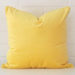 Vibrant lemon yellow cushion cover constructed from velvet fabric and shown in a large size.