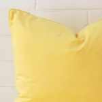 This image shows a lemon yellow cushion cover from a very close range. The large size and velvet material are more clearly shown.