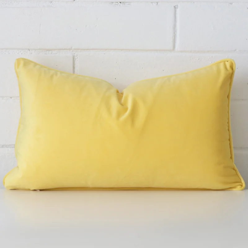 lemon-yellow-velvet-rectangular-cushion-cover-30cm-x-50cm-sc766-30 A hero shot of a rectangle cushion cover. It is made from a deluxe velvet fabric and features a lemon yellow colour.
