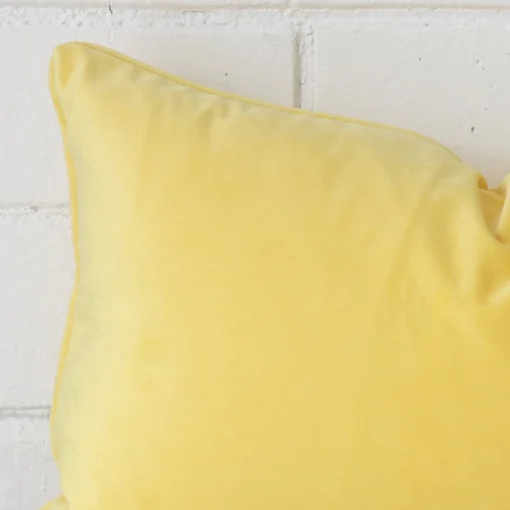 Enlarged shot of a rectangle lemon yellow cushion cover that highlights that TYPE motif on its velvet fabric.