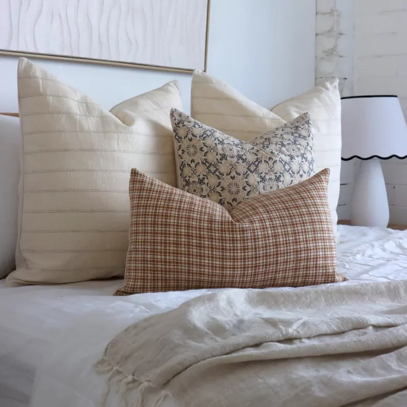 A bright bedroom showcasing 4 elegant designer from the Lennox bed cushions set.