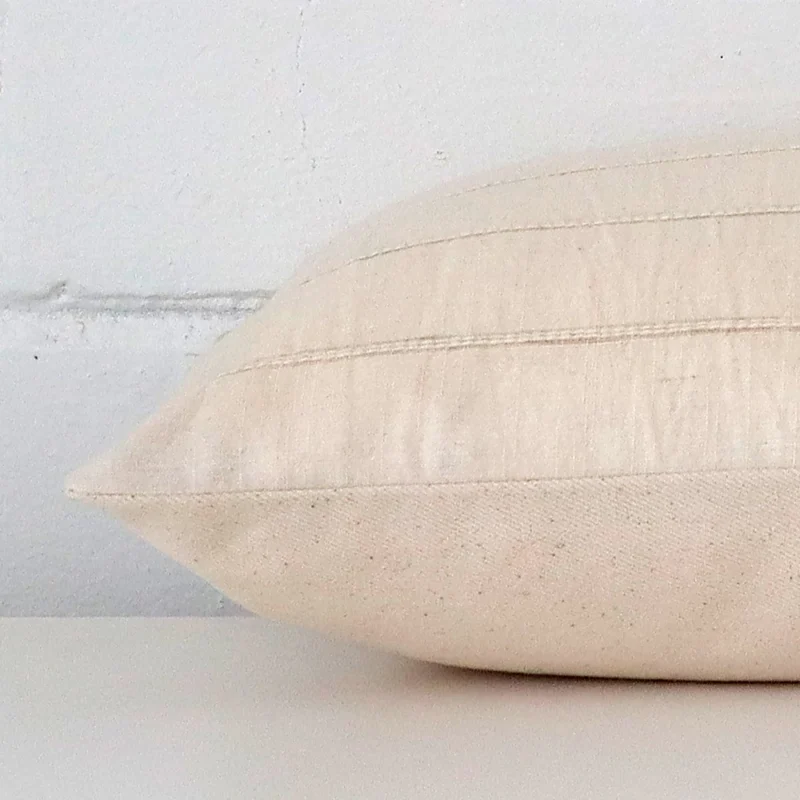 Horizontal edge view of front and back panels of a striped designer cushion in a rectangle size.