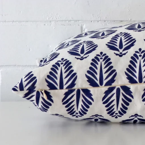 Enlarged image of the side of this blue linen cushion. The angle highlights how the large design and geometric decorative finish are joined along the seam.