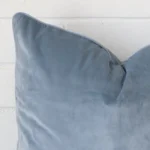 Extreme close up of a light blue cushion. The velvet fabric are shown with a much higher degree of detail.