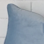 Close up of a velvet rectangle cushion in light blue colour.