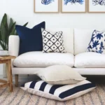 A light living room scene with Hamptons cushions on a light coloured seat.