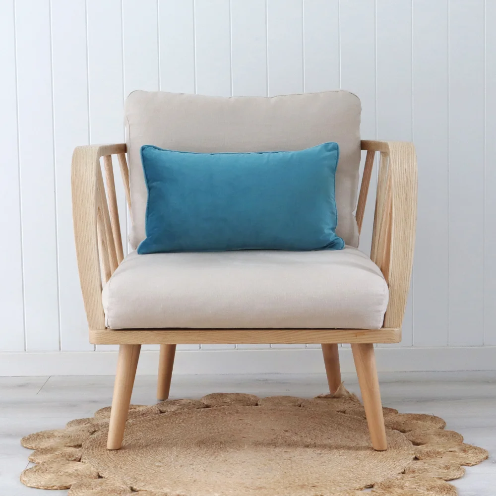 A light stylish chair with an aqua cushion placed on it.