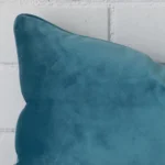 A magnified shot of a velvet cushion cover in a square size and a teal colour.