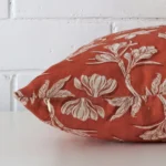 Side angle of rust floral cushion cover that has linen fabric and a large size.