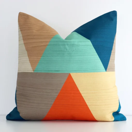 Square geometric cushion cover in colourful colour sitting upright in front of a white wall. It has been made from a quality linen material.