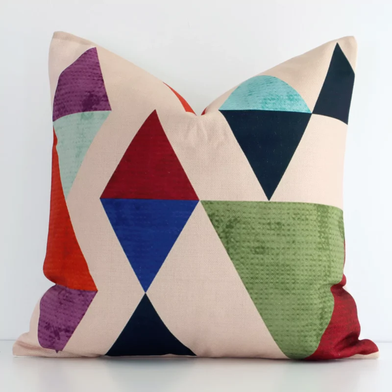 loki-pop-cushion-cover---sc187-45 A linen square cushion with a vibrant geometric design positioned upright against a white wall. The cushion features a mix of colourful prints.