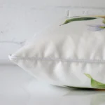 Lateral angle image of an outdoor square cushion. The design is highlighted along its seams.